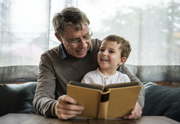 Grandfather and grandson reading a book together